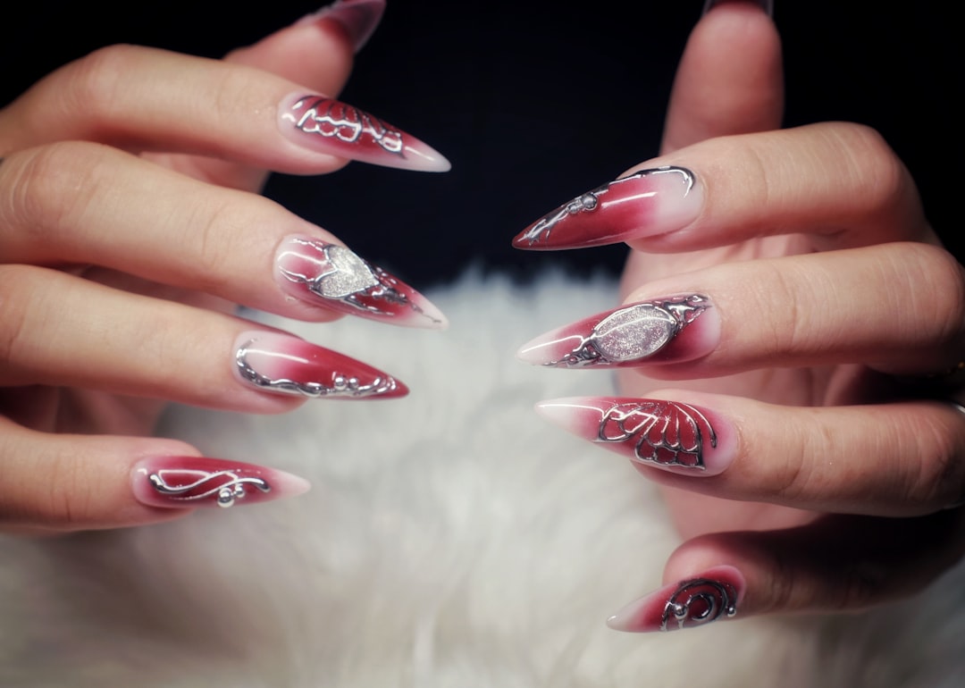womans-hands-with-long-ornate-red-and-white-stiletto-nails-ntdhtlxeonc